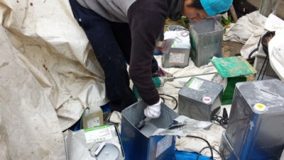 缶の中に材料を落とす職人