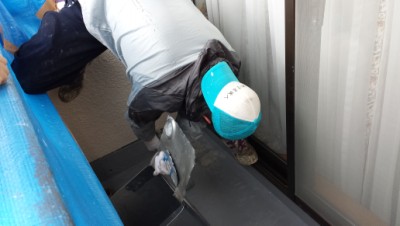 複雑な体勢でクロスを貼る職人